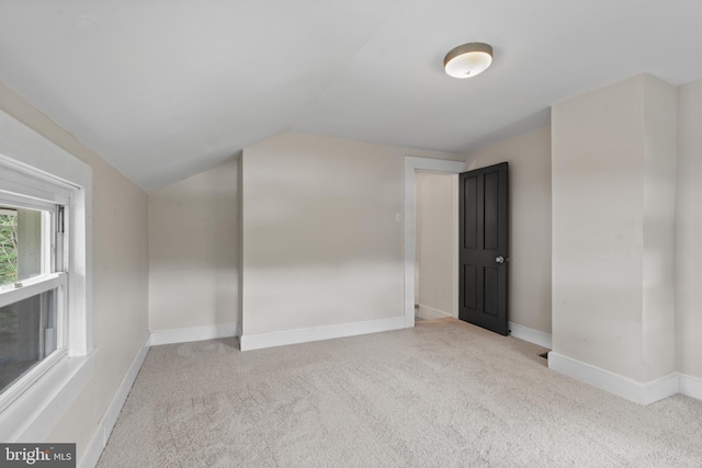 additional living space with carpet, lofted ceiling, and baseboards