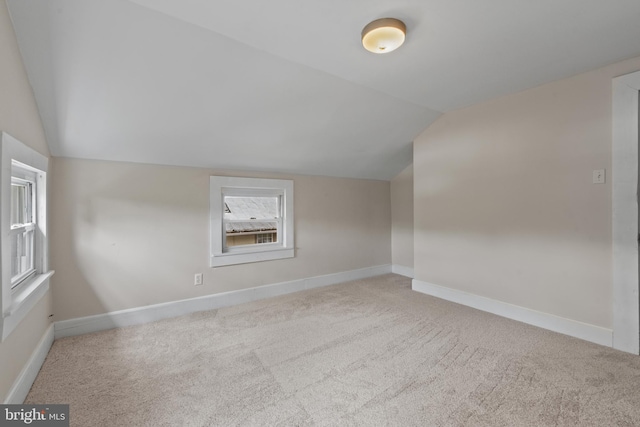 bonus room featuring lofted ceiling, carpet floors, and baseboards