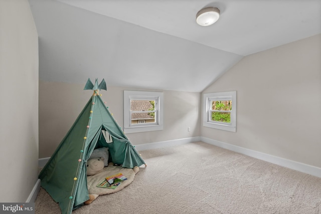 recreation room featuring vaulted ceiling, baseboards, and carpet