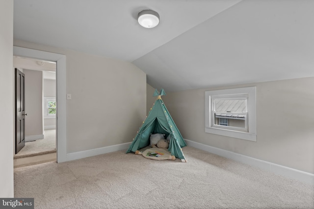 playroom featuring lofted ceiling, carpet floors, and baseboards