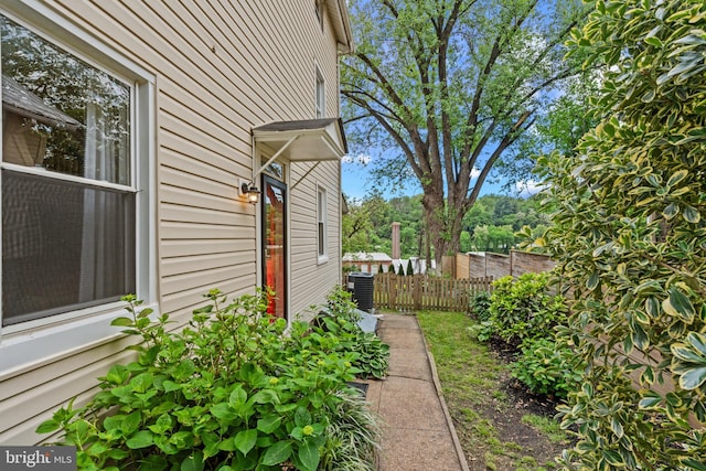 view of side of home featuring cooling unit and fence