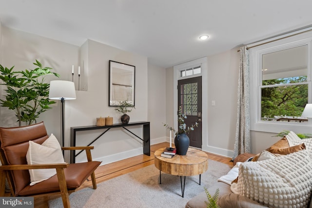 living area with wood finished floors, plenty of natural light, baseboards, and recessed lighting