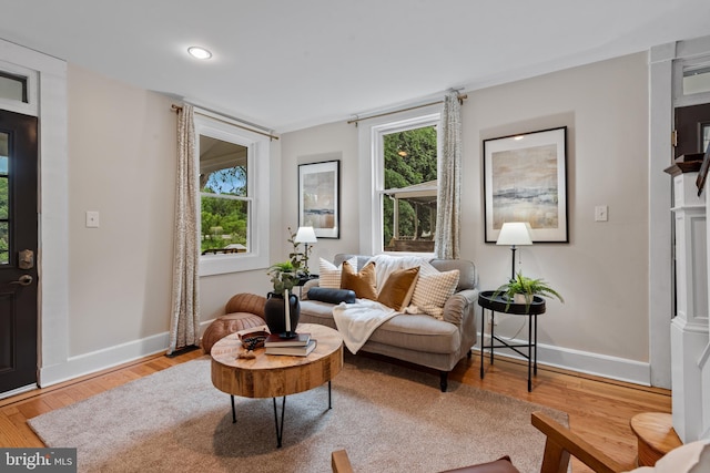 living area featuring baseboards, plenty of natural light, wood finished floors, and recessed lighting