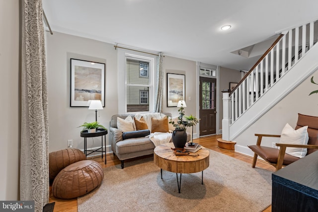 living area with wood finished floors, stairway, baseboards, and recessed lighting