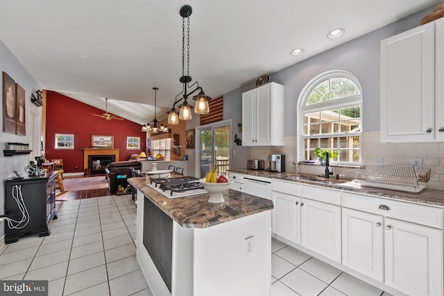 36 Crimson King Dr, Bear, DE 19701 - kitchen with white cabinets, a sink, a glass covered fireplace, a center island, and lofted ceiling