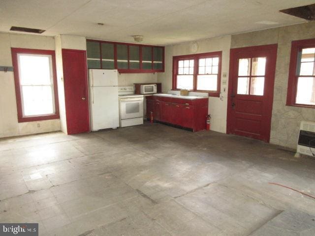 kitchen featuring heating unit, tile patterned floors, white appliances, and visible vents
