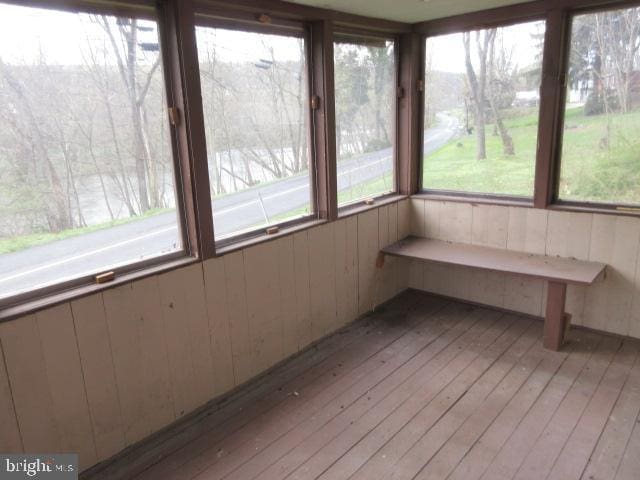 unfurnished sunroom featuring wooden walls and hardwood / wood-style floors