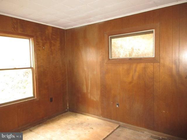 unfurnished room with wood walls