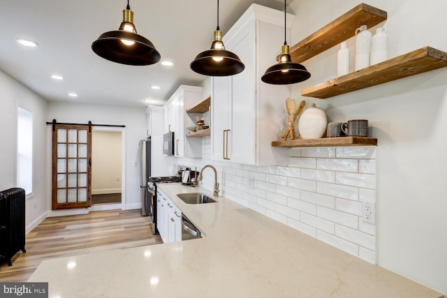 615 1st St, Lancaster, PA 17603 - kitchen featuring appliances with stainless steel finishes, open shelves, a barn door, a sink, and white cabinets