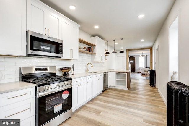 615 1st St, Lancaster, PA 17603 - kitchen with open shelves, radiator heating unit, light countertops, a sink, and stainless steel appliances