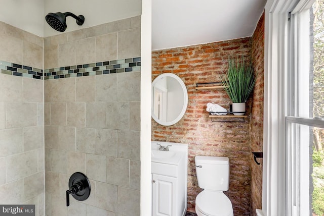 615 1st St, Lancaster, PA 17603 - bathroom featuring brick wall, vanity, toilet, and tiled shower