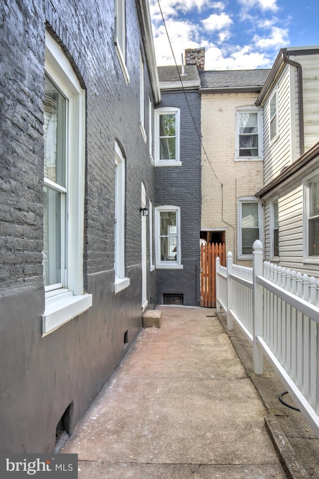 615 1st St, Lancaster, PA 17603 - view of side of property with brick siding, fence, and a chimney