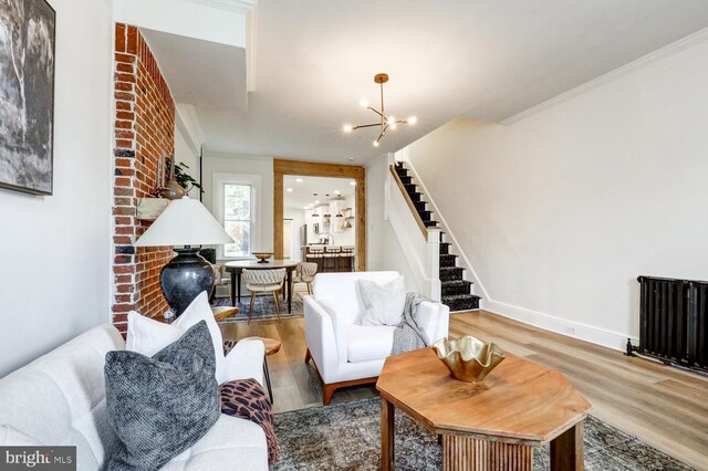 615 1st St, Lancaster, PA 17603 - living area with an inviting chandelier, radiator heating unit, wood finished floors, ornamental molding, and stairway