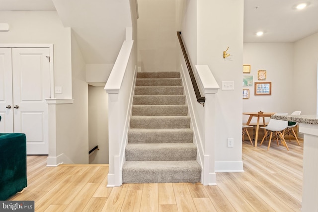 stairs with recessed lighting, baseboards, and wood finished floors