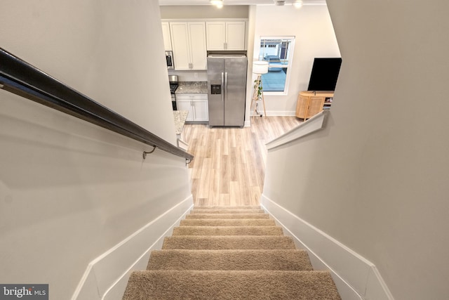 stairs featuring baseboards and wood finished floors