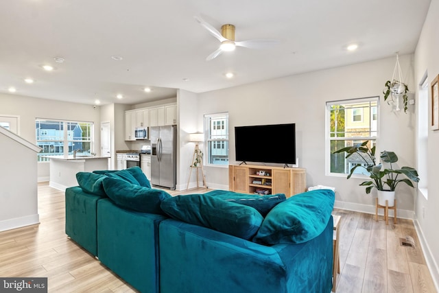 living area featuring light wood finished floors, a ceiling fan, baseboards, recessed lighting, and visible vents