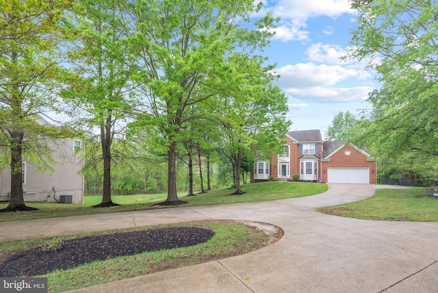 colonial home with central AC unit, brick siding, curved driveway, a front lawn, and an attached garage