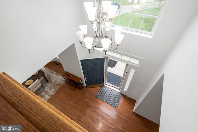 entrance foyer with wood finished floors and a notable chandelier
