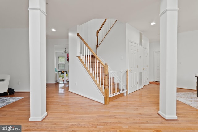 stairs featuring baseboards, decorative columns, recessed lighting, and wood finished floors