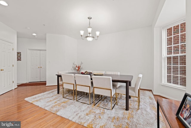 dining room with an inviting chandelier, baseboards, and wood finished floors