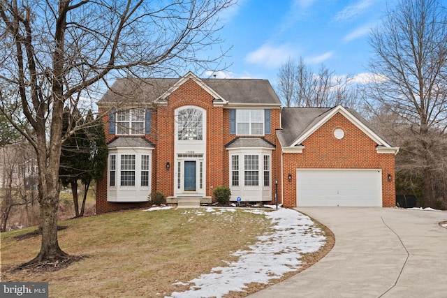 colonial inspired home with a front yard, brick siding, a shingled roof, concrete driveway, and an attached garage