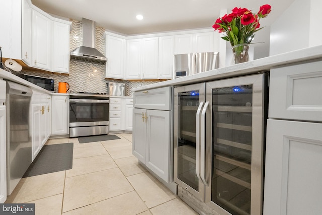 kitchen featuring wall chimney range hood, black microwave, wine cooler, white cabinets, and stainless steel electric stove