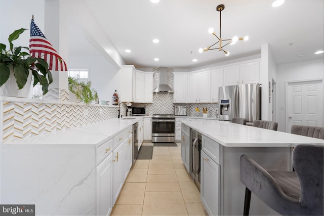 kitchen with wall chimney range hood, a large island, tasteful backsplash, a sink, and stainless steel appliances