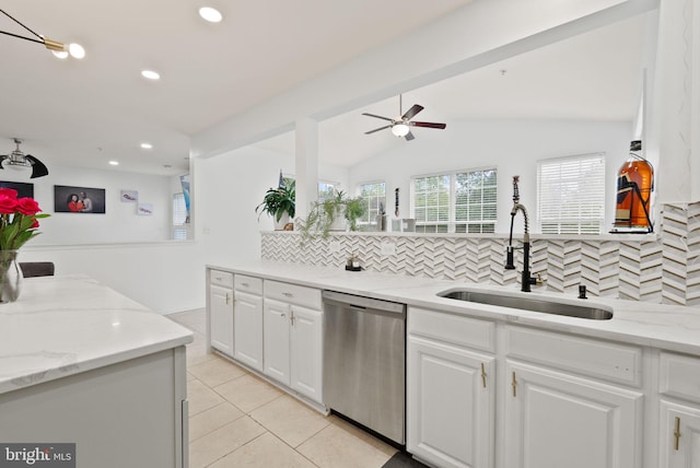 kitchen featuring stainless steel dishwasher, backsplash, ceiling fan, and a sink