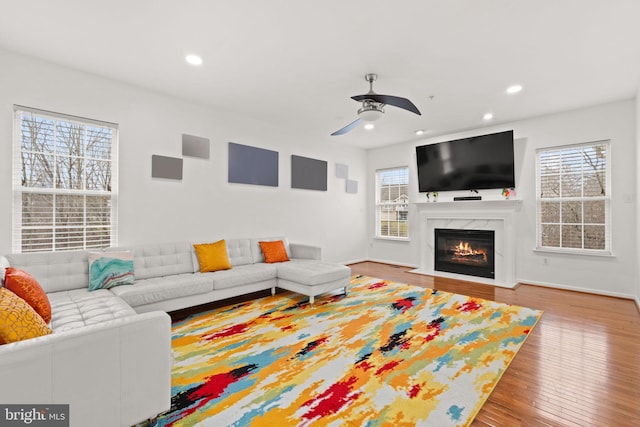 living room featuring a ceiling fan, recessed lighting, wood finished floors, and a fireplace