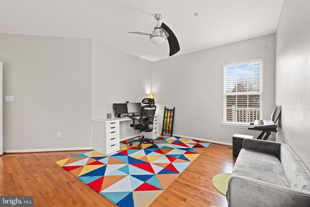 office area featuring light wood-style floors, baseboards, and ceiling fan