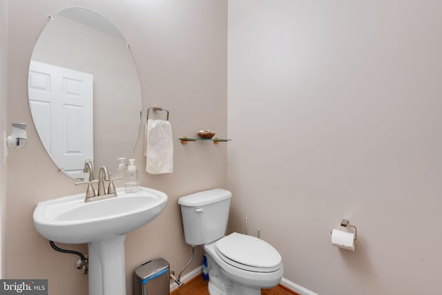 bathroom featuring baseboards, toilet, and wood finished floors