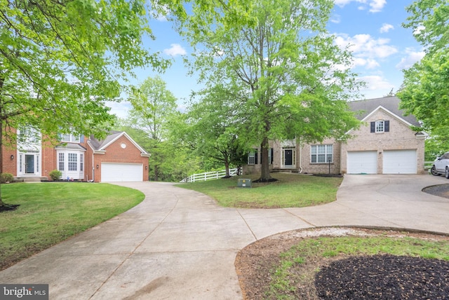 view of front of home with fence, a front yard, driveway, and brick siding