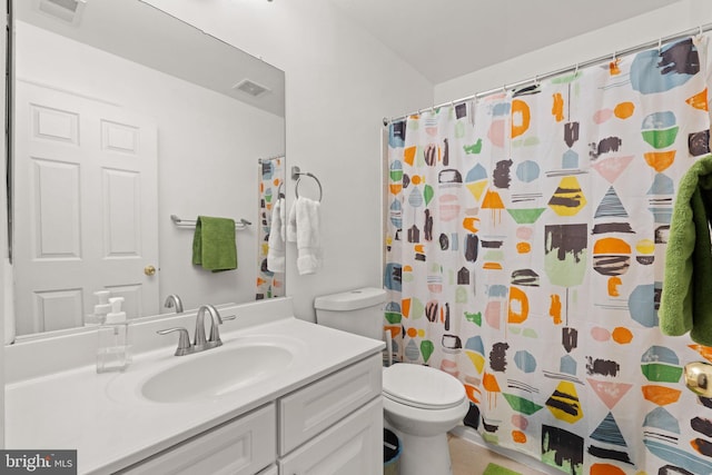 full bathroom featuring vanity, a shower with shower curtain, toilet, and visible vents
