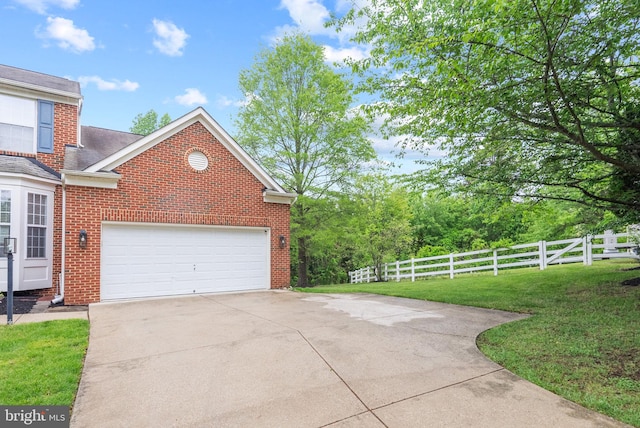 view of home's exterior featuring fence, brick siding, a garage, a lawn, and driveway