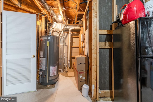 unfinished below grade area featuring freestanding refrigerator and water heater