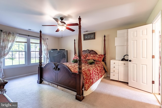 bedroom featuring ceiling fan, visible vents, light carpet, and baseboards