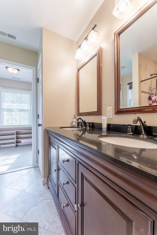 full bath featuring double vanity, visible vents, and a sink