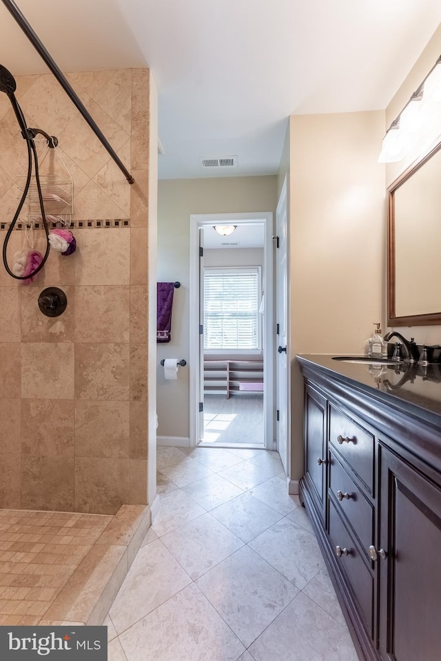 full bath with visible vents, tile patterned flooring, a tile shower, and vanity
