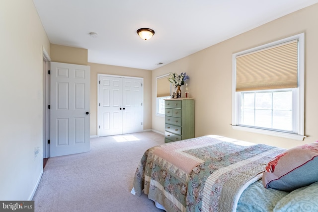 carpeted bedroom with baseboards, visible vents, and a closet