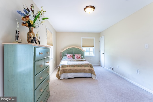 carpeted bedroom featuring baseboards and visible vents