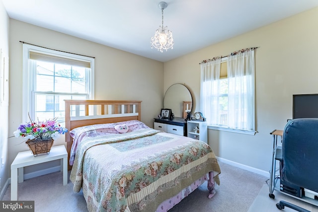 carpeted bedroom with baseboards and a chandelier