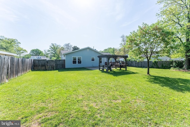 rear view of house with a yard, a pergola, and a fenced backyard