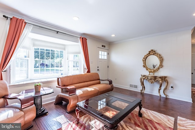 living area featuring visible vents, ornamental molding, baseboards, and wood finished floors