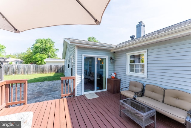 deck featuring a yard, an outdoor living space, a fenced backyard, and a patio area