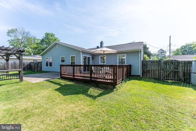 rear view of property with a fenced backyard, a gate, a wooden deck, and a lawn