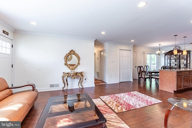 living area featuring a notable chandelier, dark wood finished floors, recessed lighting, visible vents, and ornamental molding