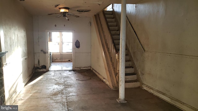 interior space featuring a ceiling fan and stairs