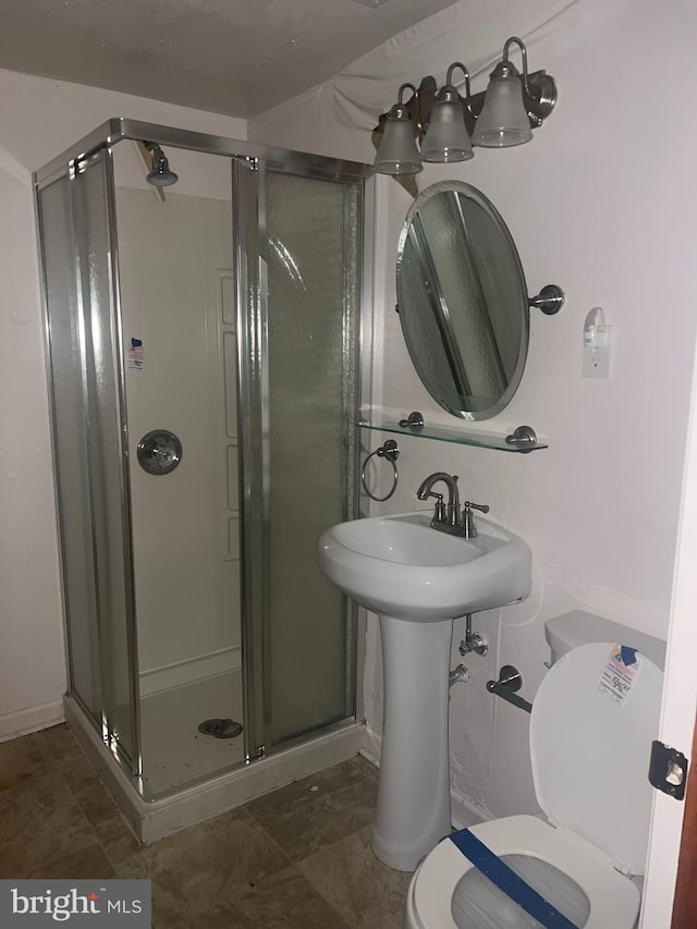 full bath with a sink, a shower stall, and toilet