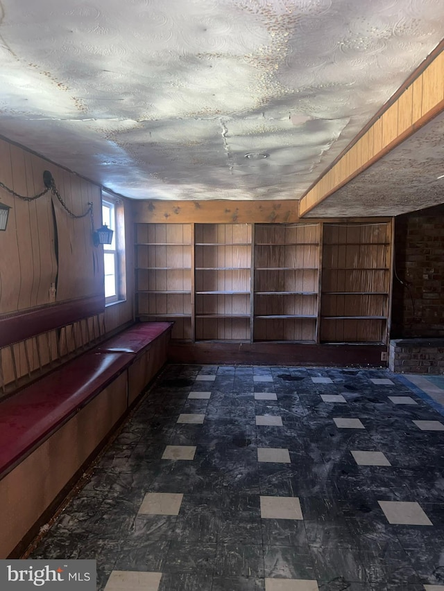 basement featuring a textured ceiling, tile patterned floors, and built in features