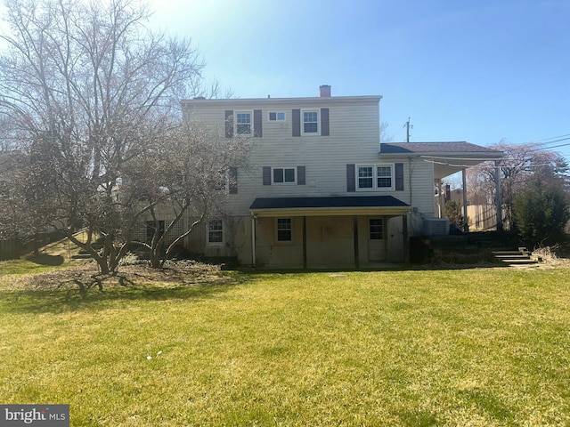 back of property featuring a yard, stairway, and a chimney
